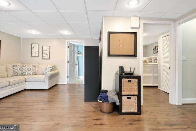 living room featuring hardwood / wood-style flooring and a drop ceiling