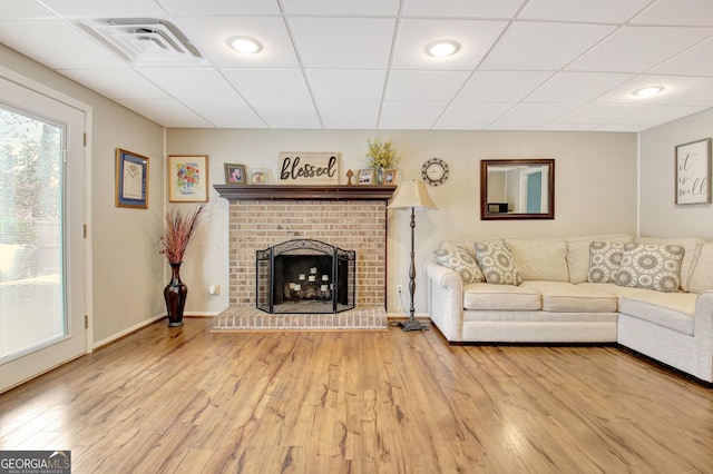 unfurnished living room with hardwood / wood-style flooring, a paneled ceiling, and a fireplace