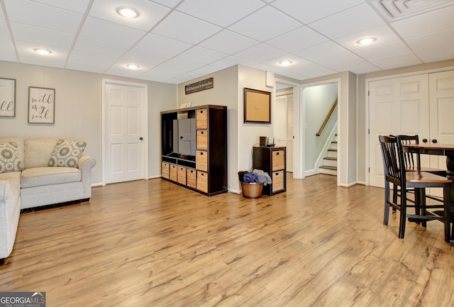 living room featuring a drop ceiling and wood-type flooring