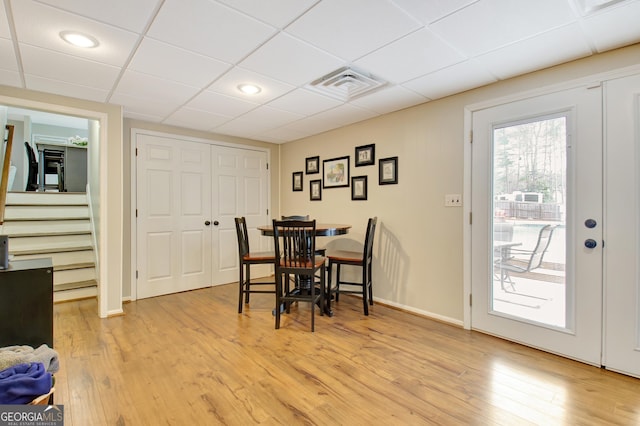 dining area featuring a paneled ceiling and light hardwood / wood-style floors