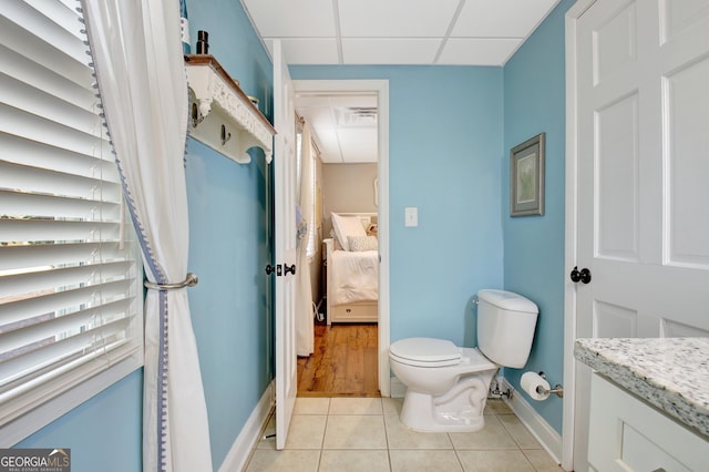 bathroom with vanity, a paneled ceiling, tile patterned floors, and toilet