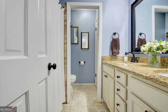 bathroom with tile patterned flooring, vanity, and toilet