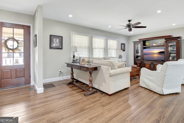 living room featuring light hardwood / wood-style flooring and ceiling fan