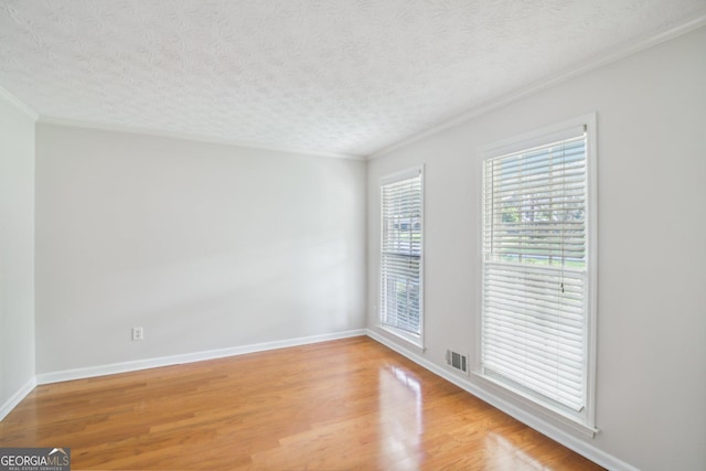 unfurnished room with crown molding, a textured ceiling, and light hardwood / wood-style floors