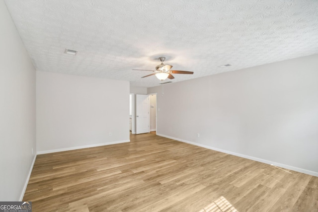 spare room with ceiling fan, light hardwood / wood-style floors, and a textured ceiling