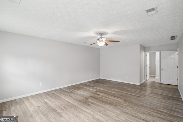 unfurnished room with ceiling fan, hardwood / wood-style flooring, and a textured ceiling