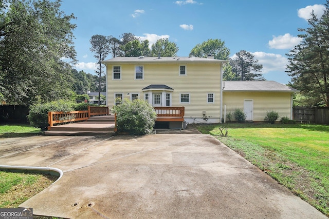 rear view of property featuring a yard and a deck