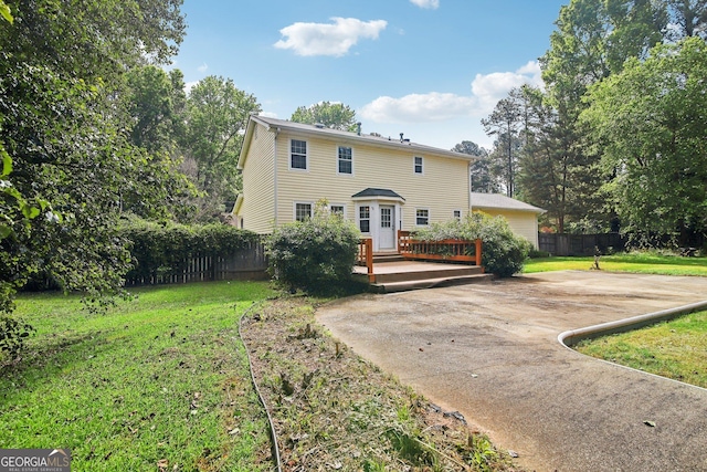 view of front facade featuring a wooden deck and a front yard