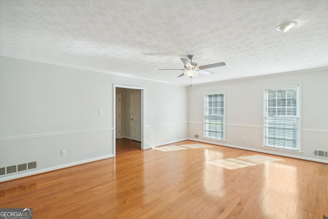 empty room featuring ceiling fan, a textured ceiling, and light wood-type flooring