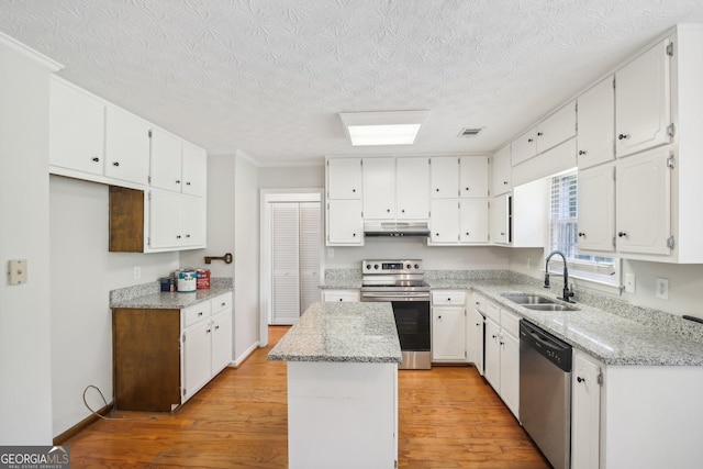 kitchen featuring sink, appliances with stainless steel finishes, white cabinetry, a kitchen island, and light wood-type flooring