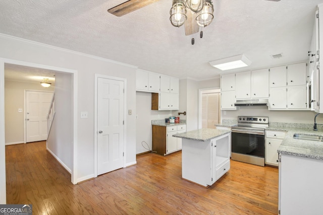 kitchen featuring a kitchen island, sink, white cabinets, and electric stove