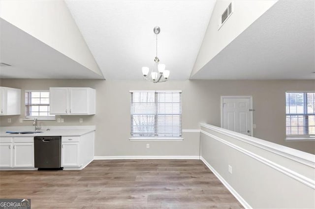 kitchen with pendant lighting, white cabinetry, black dishwasher, sink, and plenty of natural light