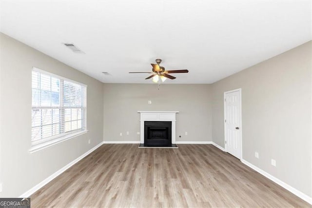 unfurnished living room with ceiling fan and light wood-type flooring