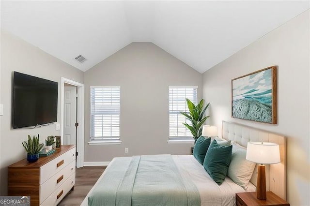 bedroom featuring dark hardwood / wood-style flooring, vaulted ceiling, and multiple windows