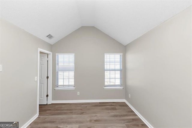 empty room featuring lofted ceiling and hardwood / wood-style floors