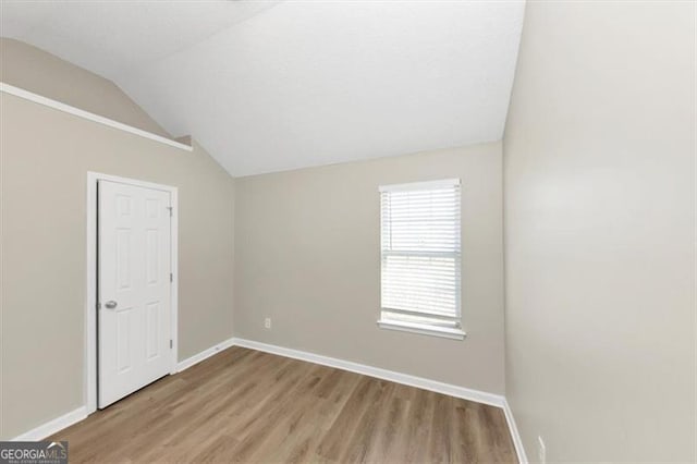 empty room featuring lofted ceiling and light hardwood / wood-style floors