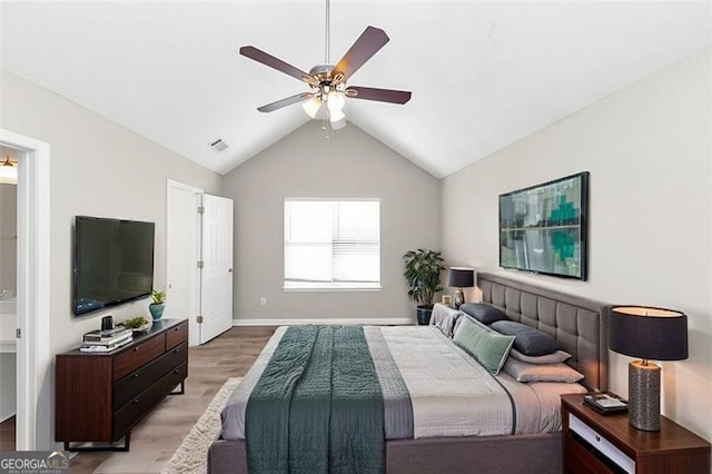 bedroom featuring hardwood / wood-style flooring, vaulted ceiling, connected bathroom, and ceiling fan