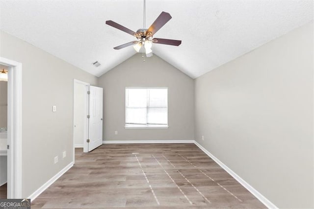 unfurnished room with lofted ceiling, ceiling fan, and light hardwood / wood-style floors