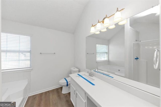 bathroom with lofted ceiling, hardwood / wood-style floors, vanity, a bath, and toilet