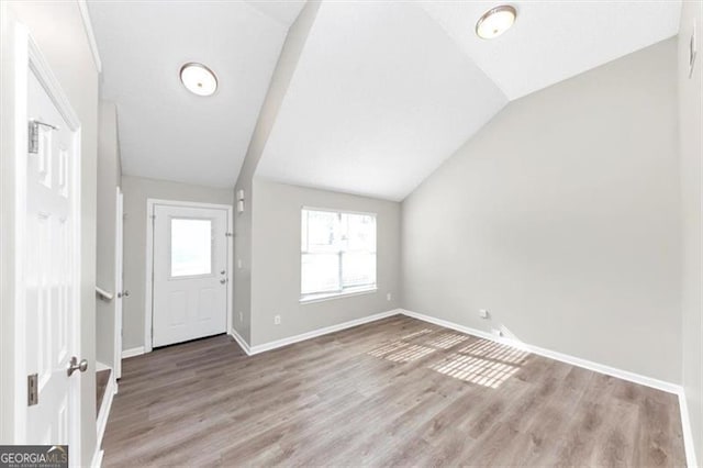 foyer featuring hardwood / wood-style flooring and vaulted ceiling