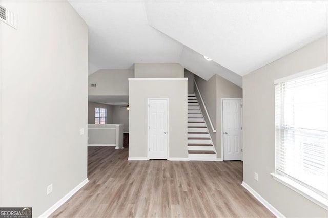 unfurnished living room featuring lofted ceiling and light hardwood / wood-style flooring