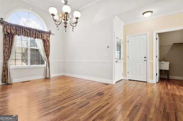 interior space featuring crown molding, hardwood / wood-style floors, and an inviting chandelier