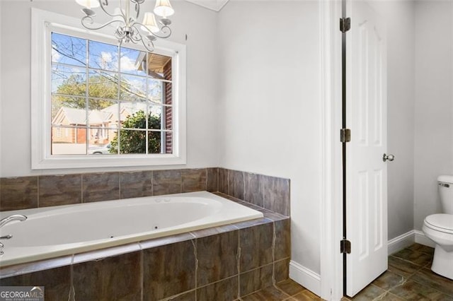 bathroom featuring an inviting chandelier, toilet, and tiled bath