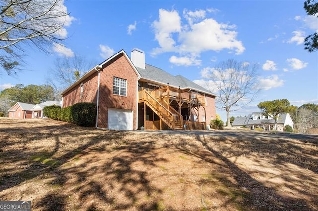 rear view of house with a wooden deck and a garage