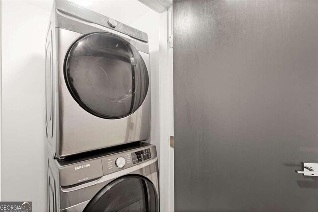 clothes washing area featuring stacked washer / drying machine