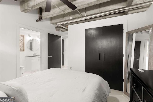 bedroom featuring ceiling fan, ensuite bathroom, sink, and a closet