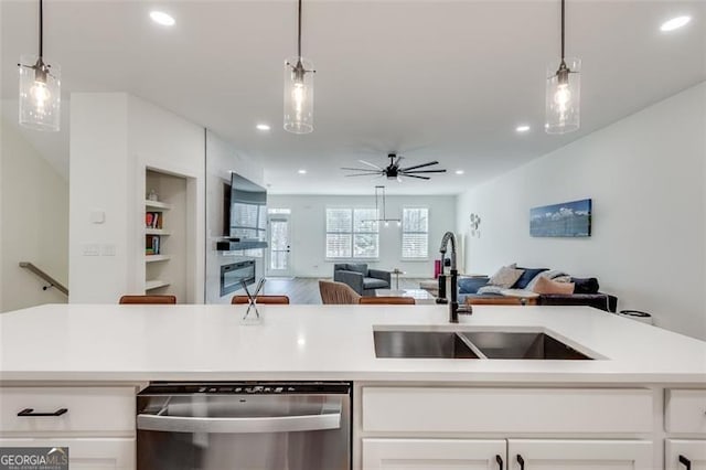 kitchen with white cabinetry, decorative light fixtures, dishwasher, and sink