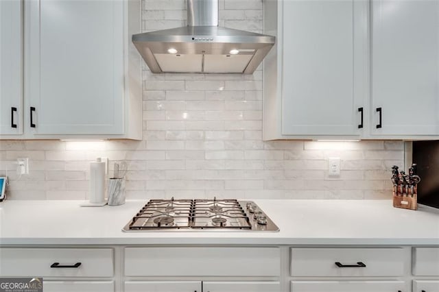 kitchen with white cabinetry, wall chimney range hood, tasteful backsplash, and stainless steel gas stovetop