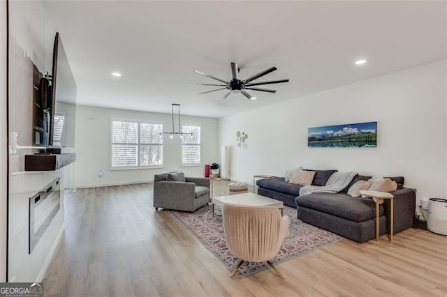 living room with ceiling fan and light wood-type flooring