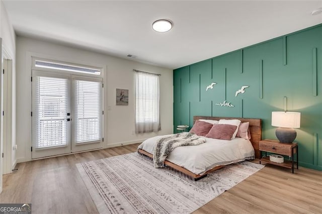 bedroom featuring access to exterior and light hardwood / wood-style flooring