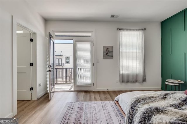 bedroom featuring access to exterior and light hardwood / wood-style flooring