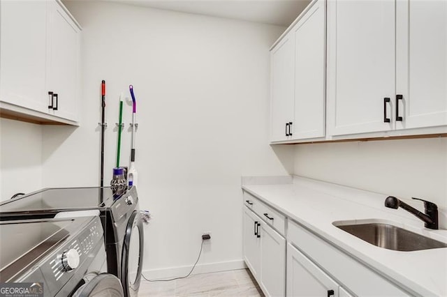 laundry area with cabinets, separate washer and dryer, and sink