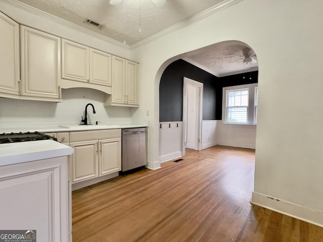 kitchen with sink, dishwasher, ceiling fan, ornamental molding, and a textured ceiling