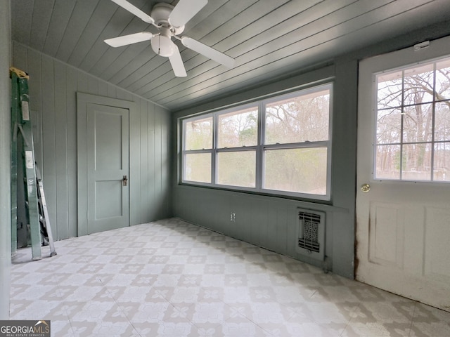 unfurnished sunroom featuring ceiling fan, vaulted ceiling, heating unit, and wooden ceiling