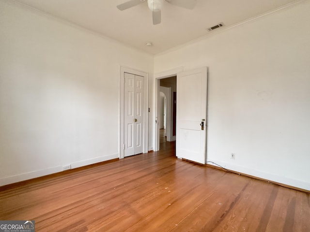 empty room featuring ceiling fan, ornamental molding, and hardwood / wood-style floors