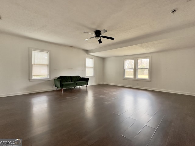 unfurnished room featuring dark wood-type flooring, ceiling fan, and a textured ceiling