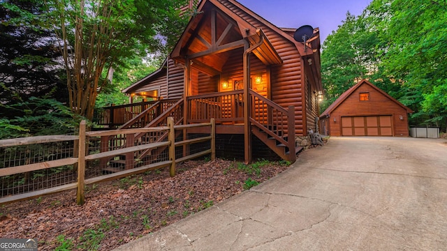 log home featuring a garage and an outdoor structure