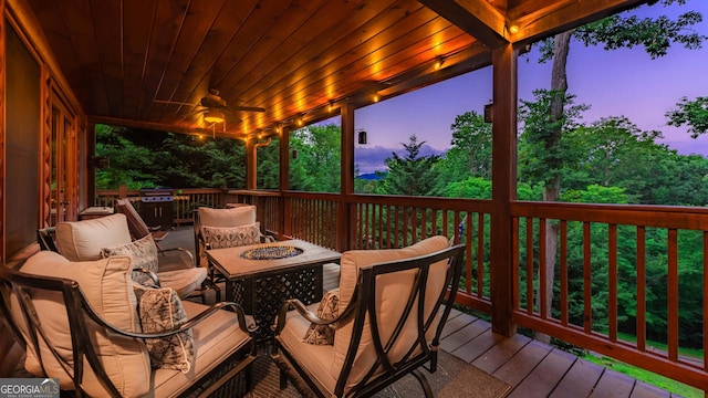 deck at dusk featuring a fire pit and ceiling fan