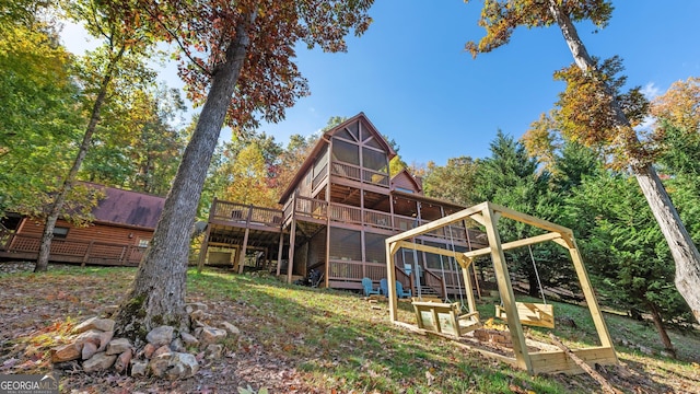 back of property with a sunroom and a deck