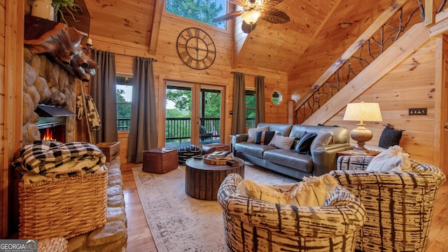 living room with high vaulted ceiling, wood walls, wood-type flooring, ceiling fan, and french doors