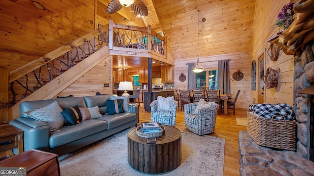 living room featuring wood ceiling, ceiling fan, hardwood / wood-style floors, high vaulted ceiling, and wood walls