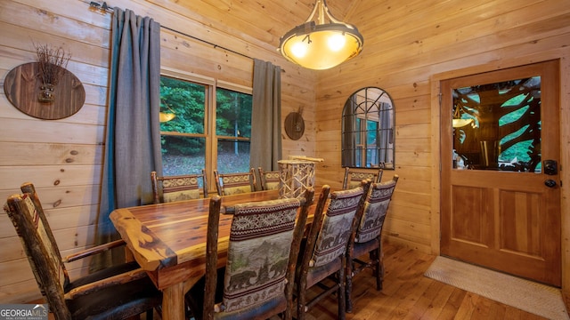 dining room with hardwood / wood-style floors and wood walls