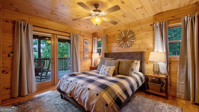 bedroom featuring french doors, wood walls, wood ceiling, wood-type flooring, and access to exterior