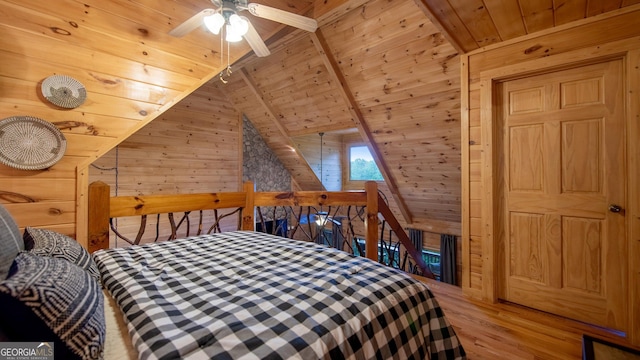 bedroom with vaulted ceiling with beams, wood walls, hardwood / wood-style floors, and wooden ceiling