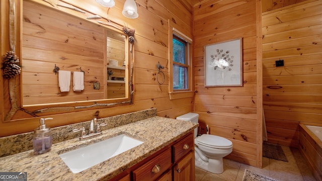 bathroom with vanity, tile patterned flooring, wooden walls, and toilet