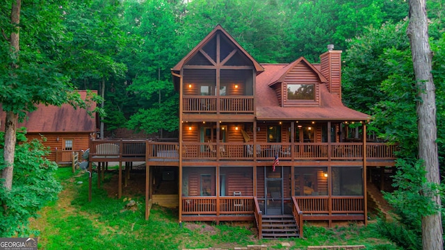 rear view of house featuring a balcony and a deck